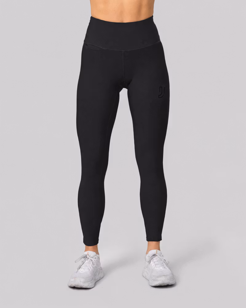 Woman wearing black Flash Warm Tights with a high waist, showing the full-length fit for winter running.