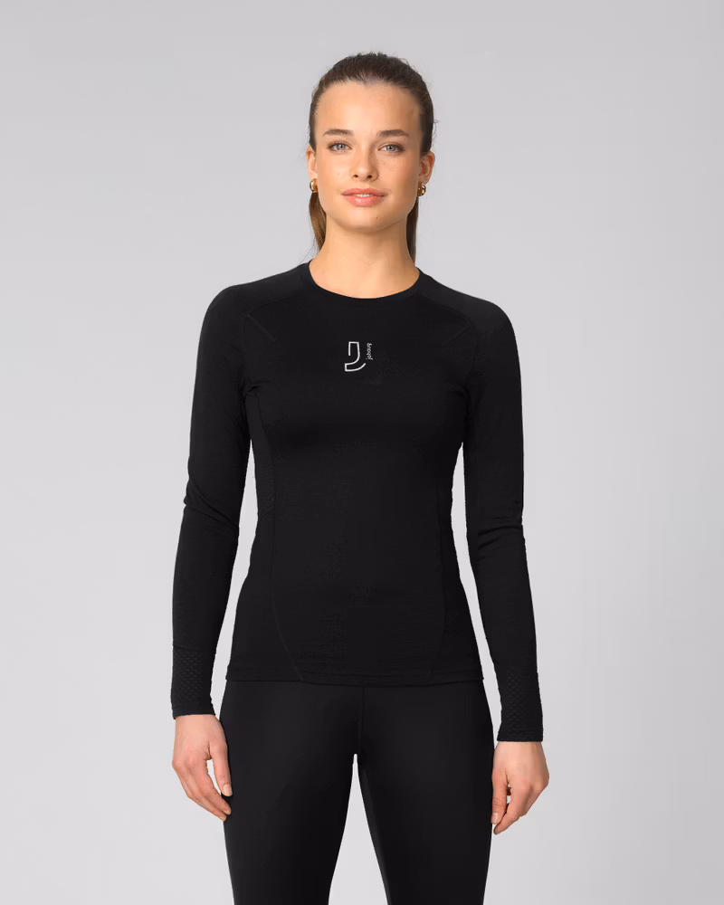 Woman wearing a black long-sleeve baselayer top with small logo detail