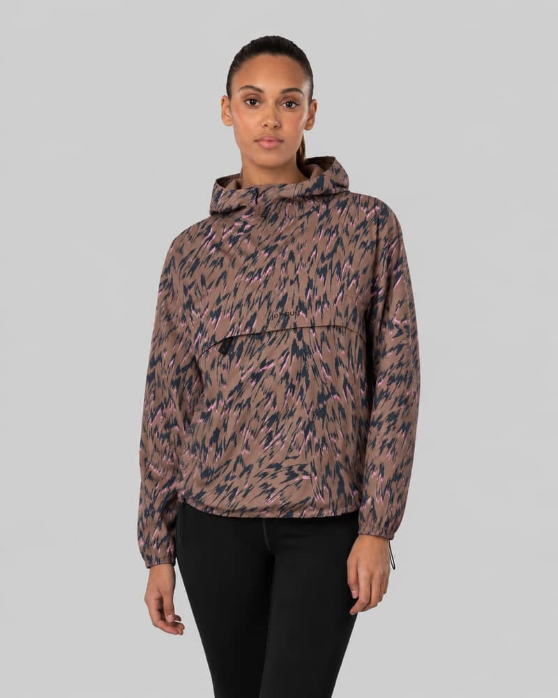 Woman wearing a brown patterned Johaug anorak pullover jacket, front view, against a light gray background