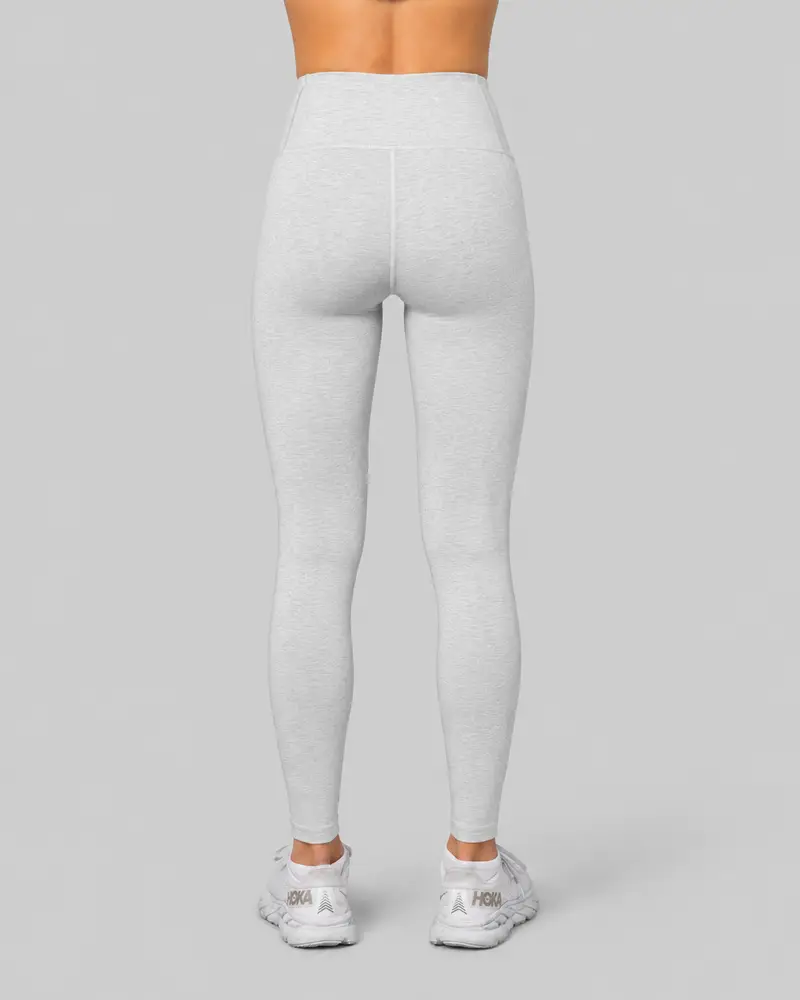 Woman wearing gray Johaug leggings, rear view from waist down, against a light gray background