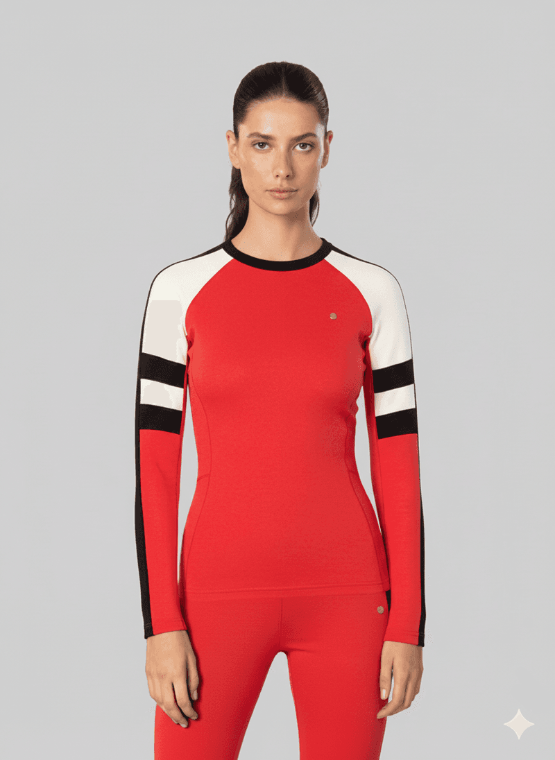 Woman wearing a red, black, and white colorblock baselayer top and leggings