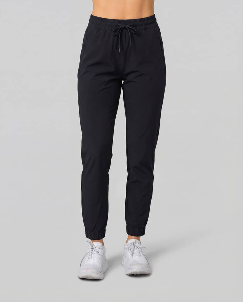 Woman wearing black Johaug Energy Pants, showing the flattering high-waist fit and elastic cuffs for a sporty lifestyle look.