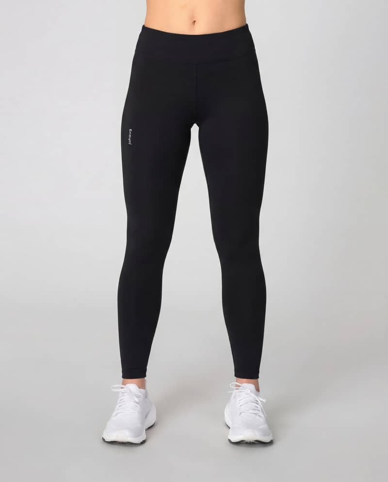 Woman wearing black Johaug Energy Tights, showing the high-waist fit and full-length design for yoga or studio workouts.