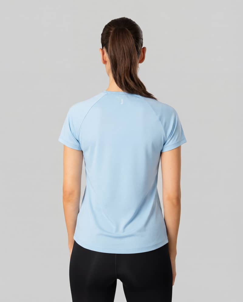 Back view of a woman wearing the light blue Johaug Energy T-Shirt, showing the tee's regular fit and athletic style.