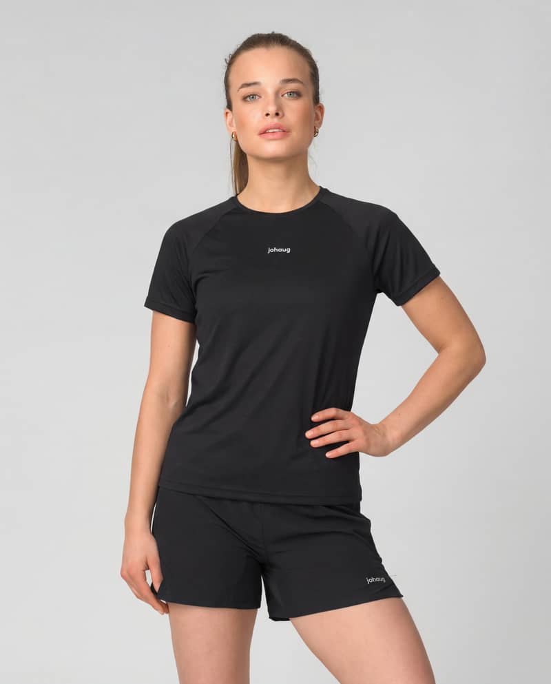Woman wearing the black Johaug Energy T-Shirt with matching shorts, creating a classic activewear set for training.