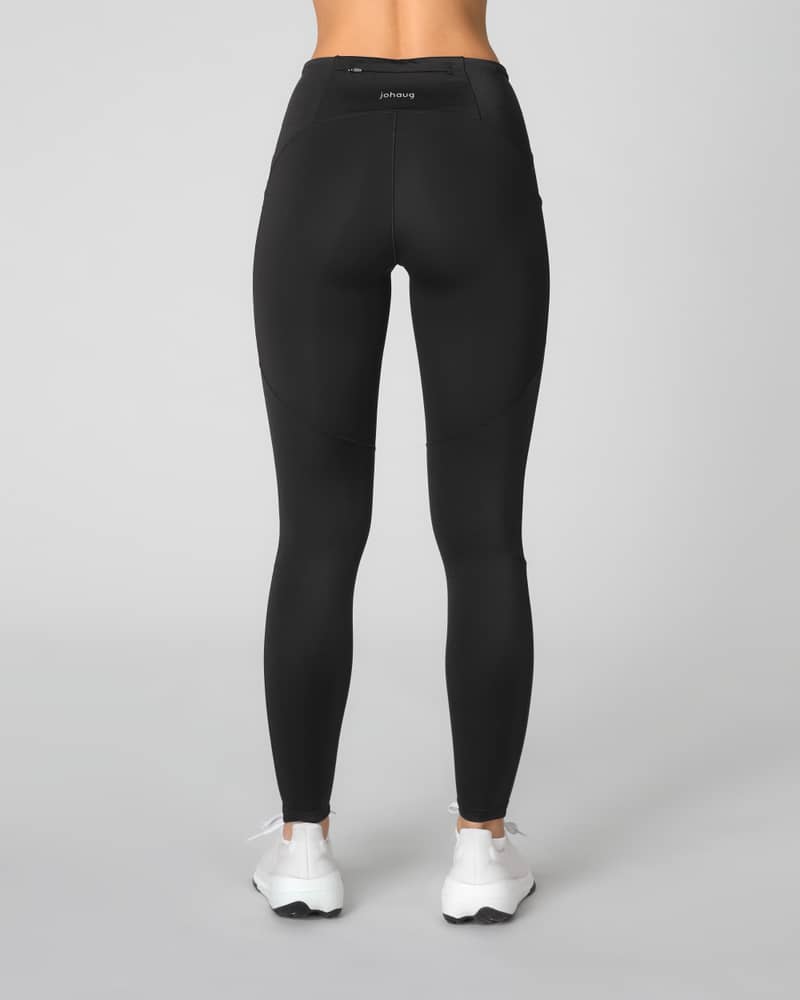 Back view of a woman in Johaug black Impact Tights with a wide waistband and squat-proof, four-way stretch fabric.