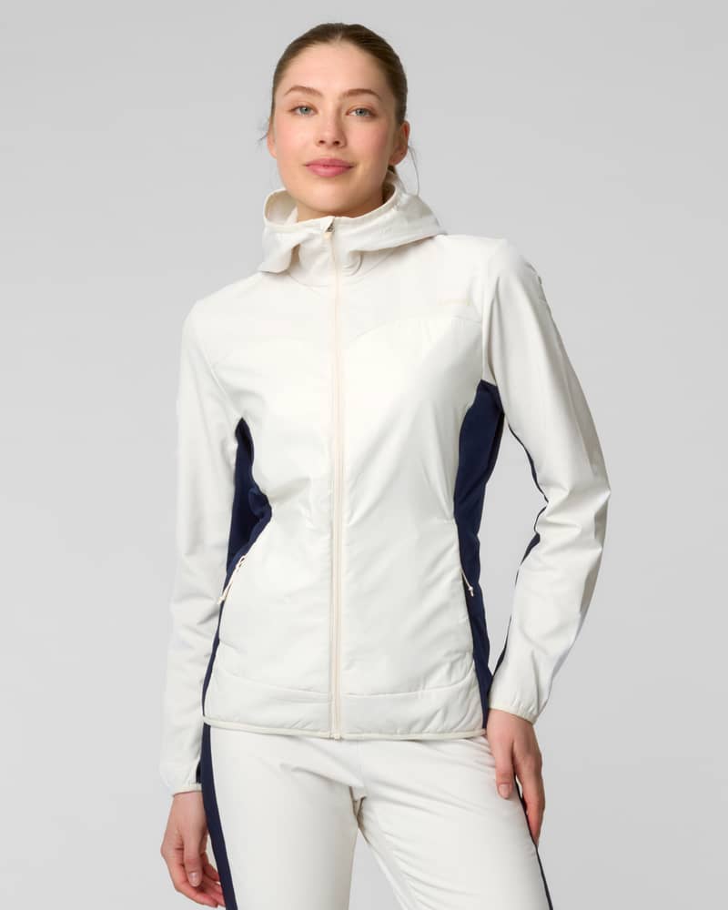 Front view of a woman wearing a white full-zip jacket with navy side panels