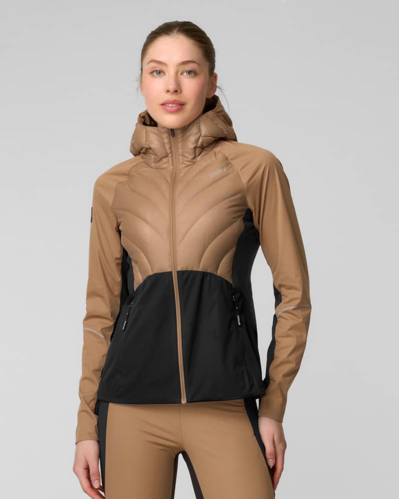 Woman adjusting the collar of a camel and black colorblock zip-up jacket