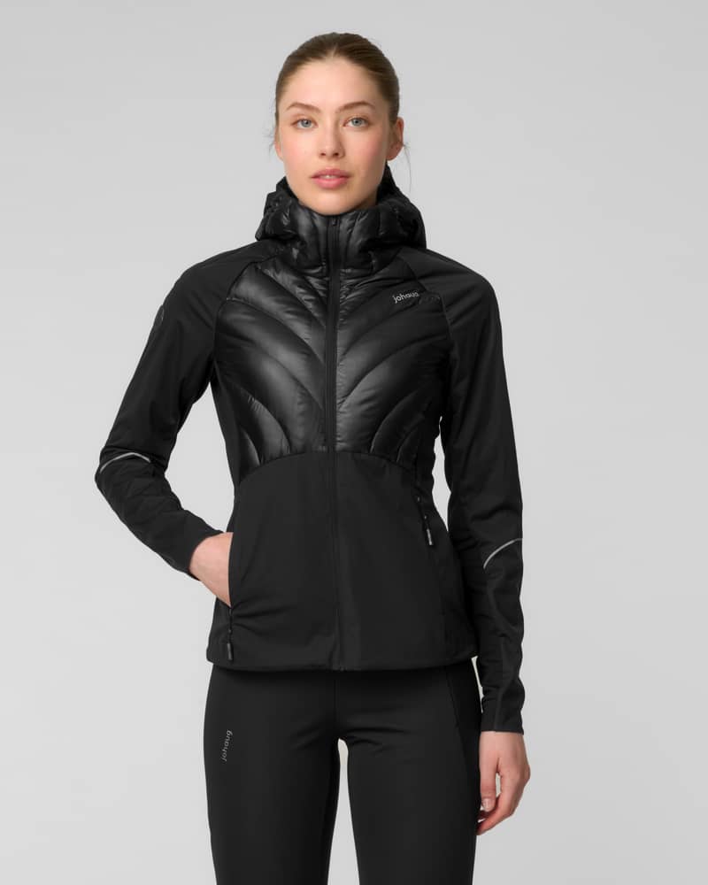 Front view of a woman wearing a black hooded jacket with a quilted chest panel