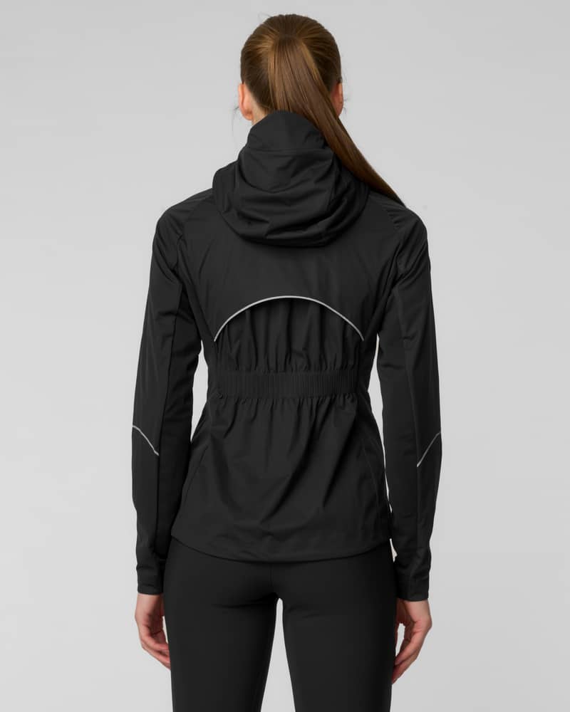 Back view of a woman wearing a black hooded jacket with reflective piping details