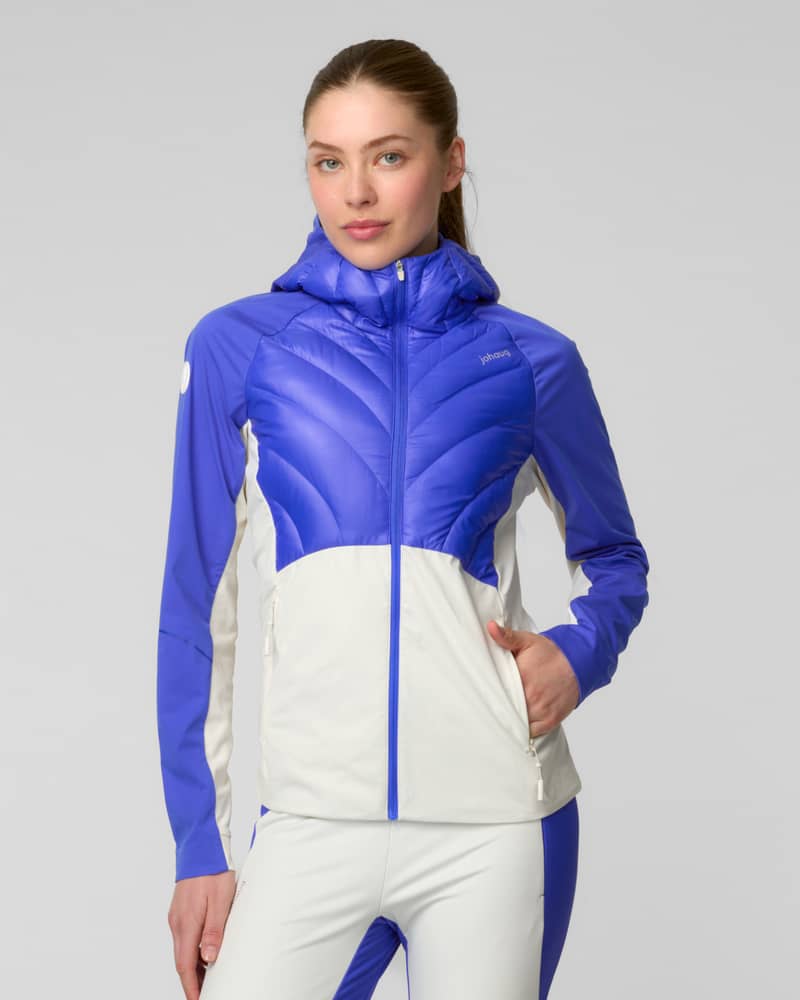 Woman wearing a blue and white colorblock puffer jacket, standing on a staircase