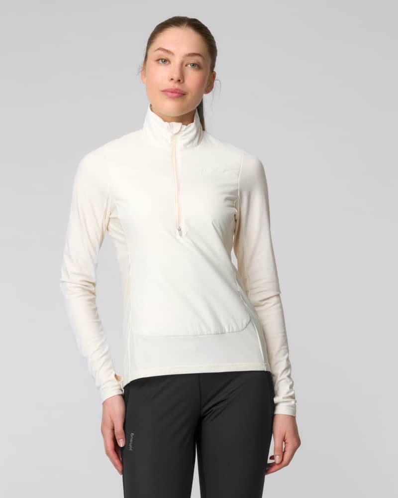 Front view of a woman wearing an ivory quarter-zip fleece sweater with thumbhole cuffs