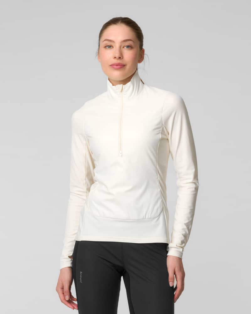 Front view of a woman wearing an ivory quarter-zip fleece sweater with a bungee hem