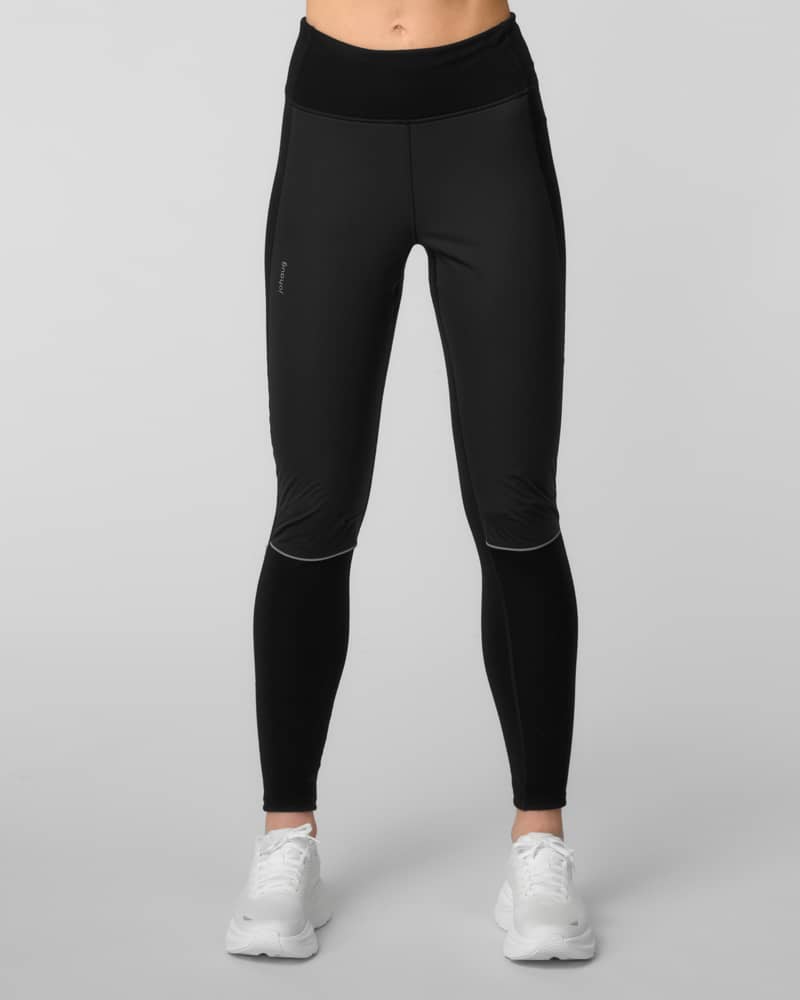 Front view of black running tights with a side leg pocket and reflective seam