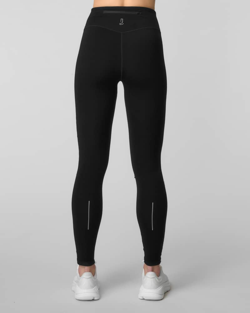 Back view of black running tights with reflective calf detailing