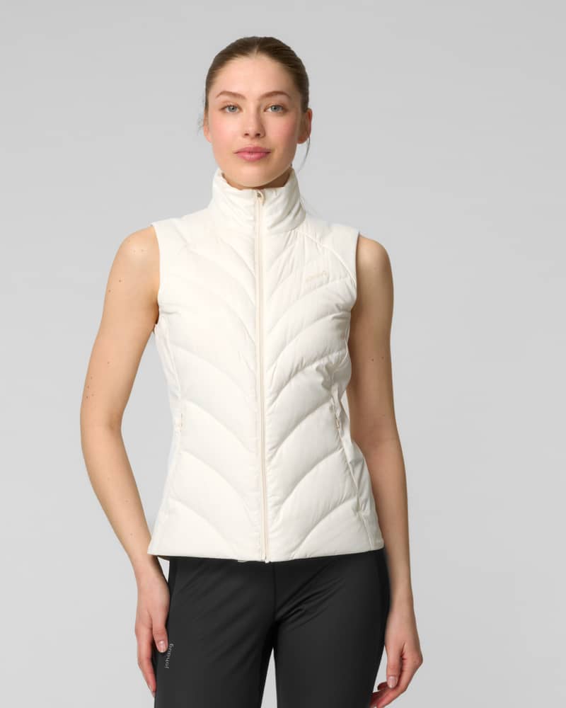 Front view of a woman wearing a cream quilted sleeveless vest